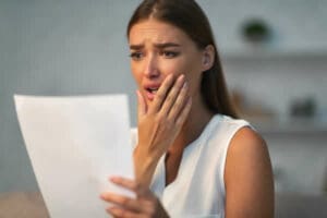 woman shocked when reading a letter from insurance company